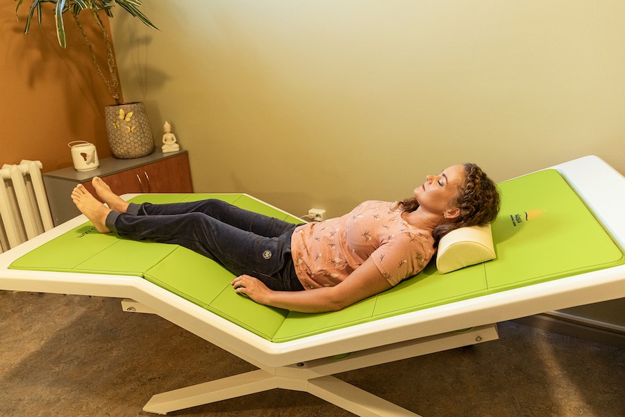 A woman is lying on a vibro-acoustic bed in a Värska spa treatment centre.