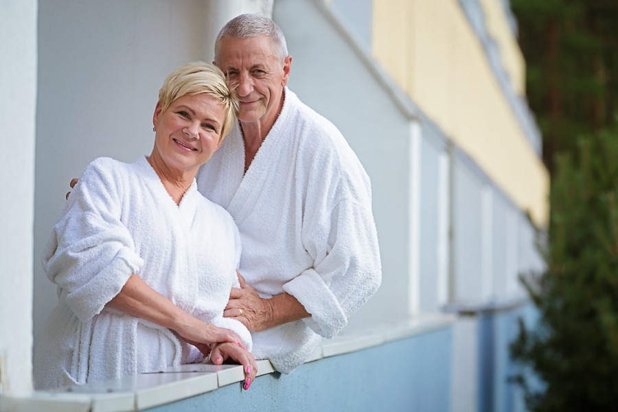 A senior couple in white bathrobes on the balcony of the Värska sanatorium hotel.