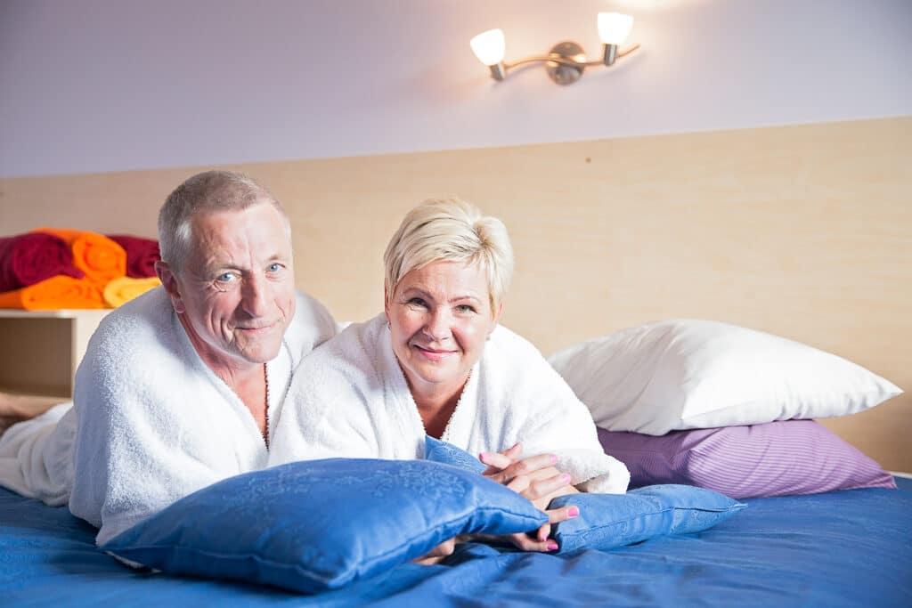 Пара пожилых людей отдыхает в номере санатория в лечебном центре курорта Вярска.