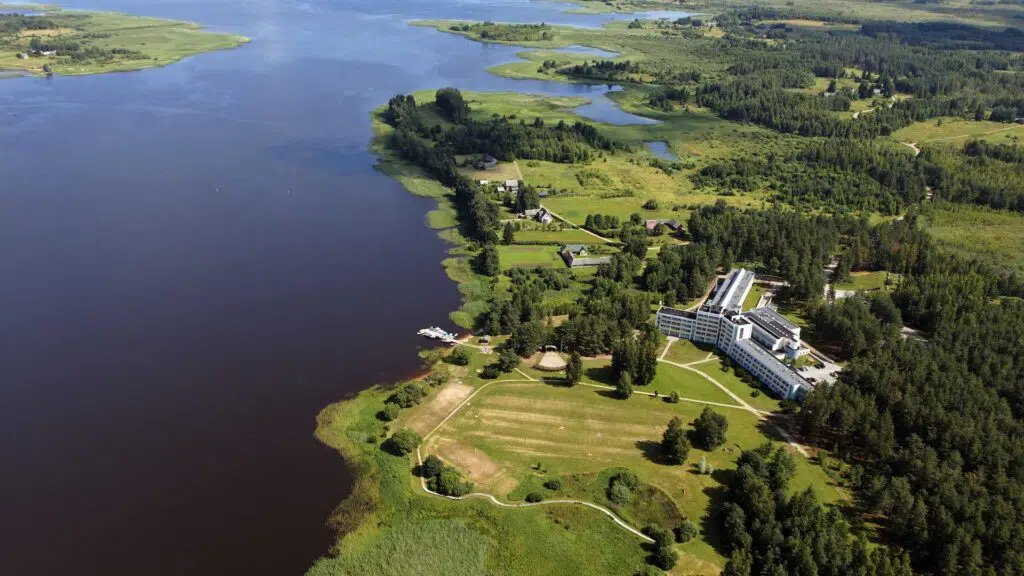 An aerial view of the Värska spa hotel building in the middle of the forest on the shores of Värska Bay.
