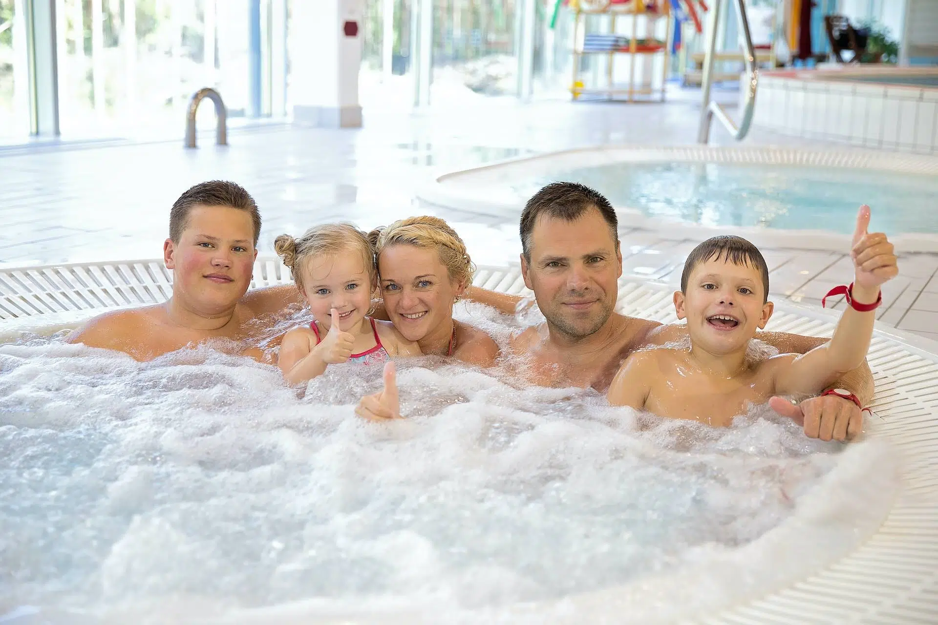 Семья в водном центре наслаждается гидромассажной ванной с минеральной водой в лечебном центре курорта Вярска.